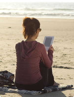 reading kindle on beach